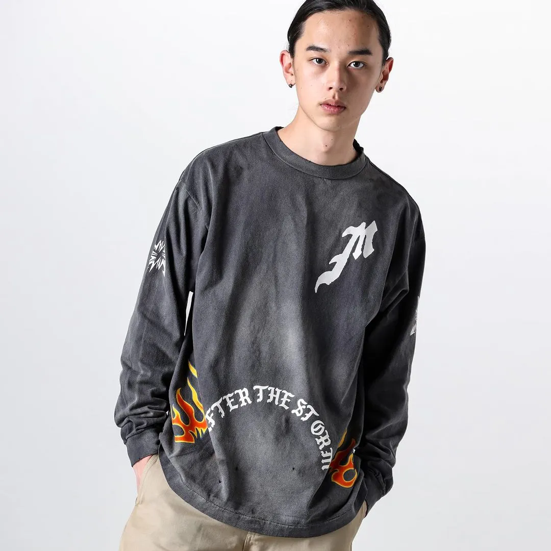 SAINT Mxxxxxx M/AFTER LS_TEE/BLACK Flame arrow Letter M retro distressed long tee Washed black S-XL Tubular fabric Assute ready-made garments dyed The whole piece is sprayed with horse-hair spray and then sprayed again to fade the color. The collar and cuffs are frayed. Many places are frayed. Extra large printing position. Very difficult to print. Complete accessories. With little angel anti-counterfeiting label.